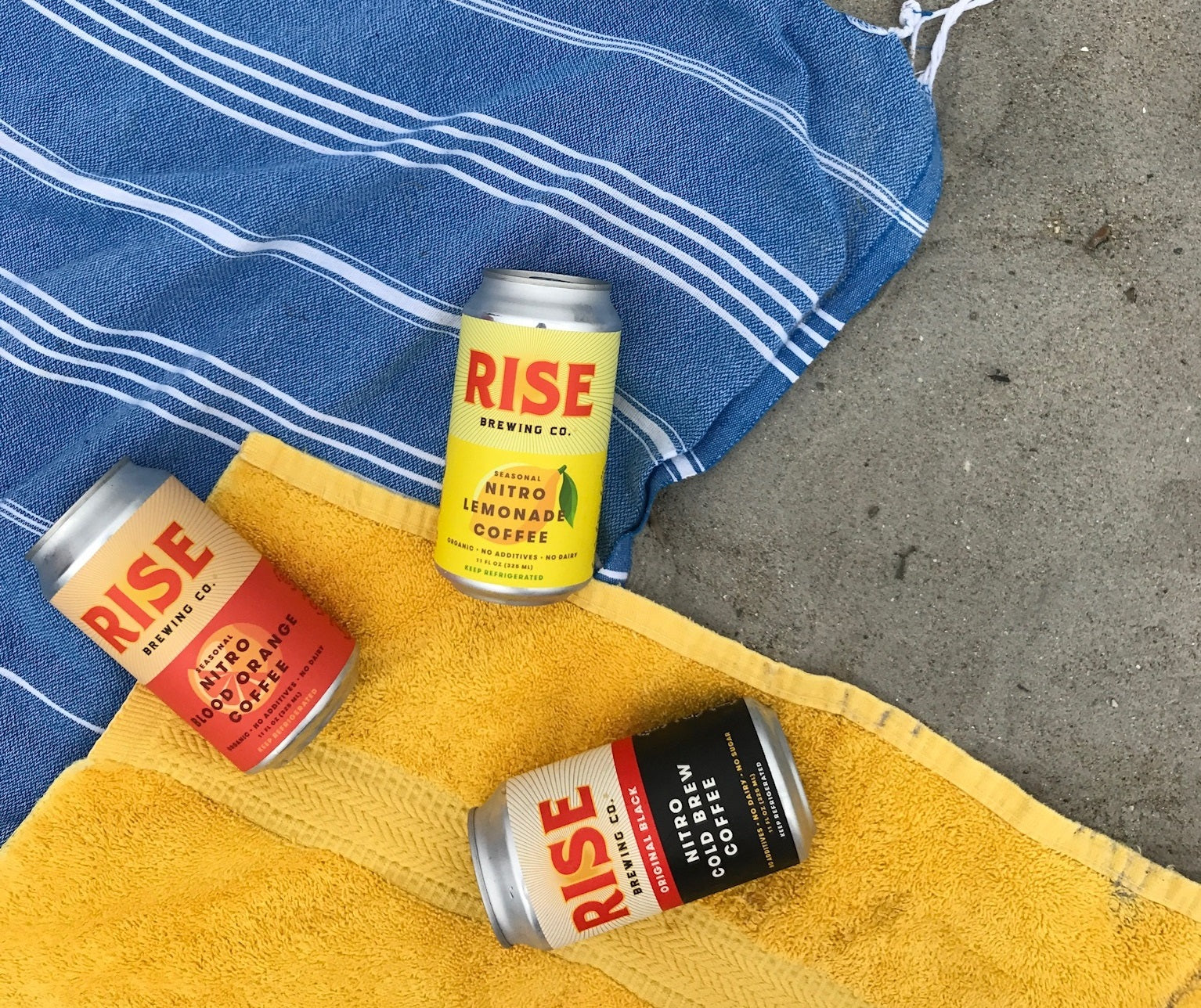 RISE Brewing Co. nitro cold brew coffee in a can in Original Black, Blood Orange, and Lemonade flavors